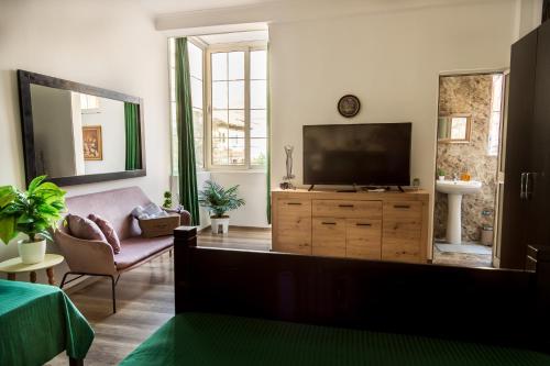 een woonkamer met een televisie op een houten dressoir bij The Tropical House Tirana in Tirana
