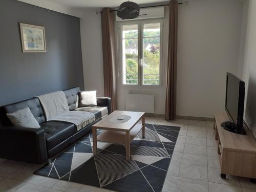 ein Wohnzimmer mit einem Sofa und einem Tisch in der Unterkunft SAPHIR in Nogent-sur-Oise