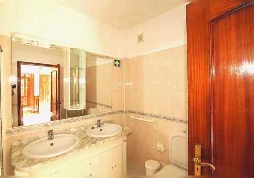 uma casa de banho com 2 lavatórios e um espelho grande em Olival Beach Villa with Pool walking distance to Beach em Armação de Pêra