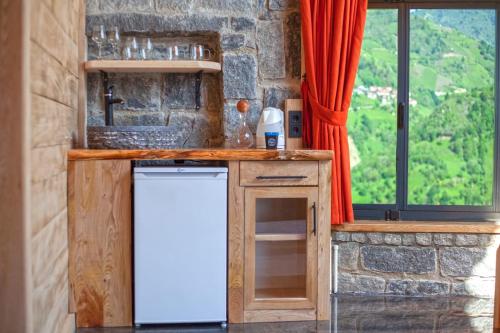 a kitchen with a white refrigerator and a window at Dastavi Dağ Evleri in Çamlıhemşin