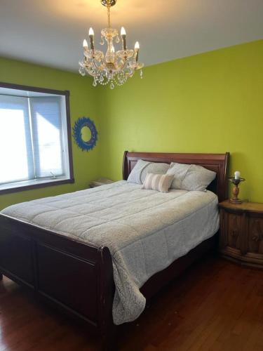 a bedroom with a large bed with a chandelier at Hotel/Home in Windsor
