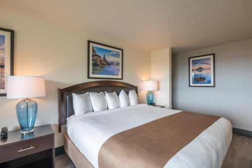 a hotel room with a large bed and two lamps at Bandon Inn in Bandon