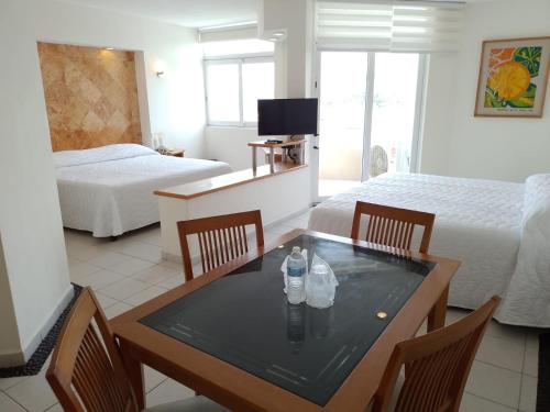 a hotel room with a table and two beds at Angeles Suites & Hotel in Veracruz