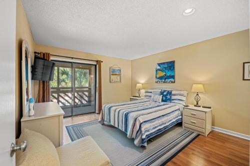 a bedroom with a bed and a sliding glass door at Heron Pointe C8 in Myrtle Beach