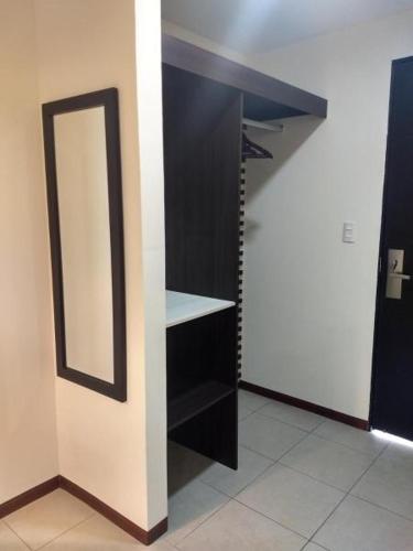a closet with a mirror and a black shelf at Angeles Suites & Hotel in Veracruz