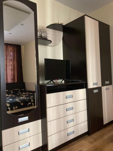 a bedroom with a dresser with a mirror and a bed at Apart 47 in Smolyan