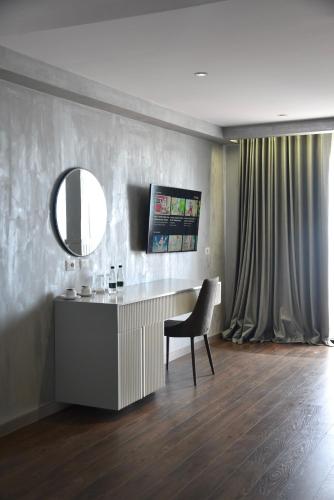 a room with a desk with a chair and a mirror at Royal G Max in Golem