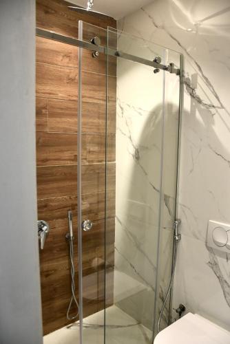 a glass shower in a bathroom with a toilet at Royal G Max in Golem