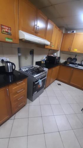 uma cozinha com armários de madeira e um forno com placa de fogão em Bunk bed private room Avani em Dubai