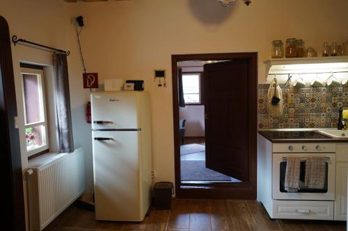 a kitchen with a refrigerator and a sink and a door at Drevenica Harmony in Ružomberok