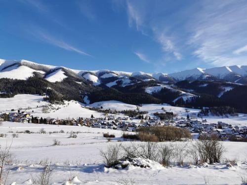 a town in the snow with mountains in the background at Drevenica Harmony in Ružomberok