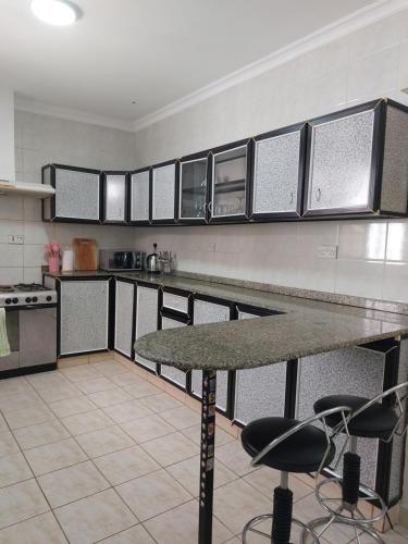 una cocina con encimera y algunas sillas. en Julie's Marvelous home, en Dar es Salaam