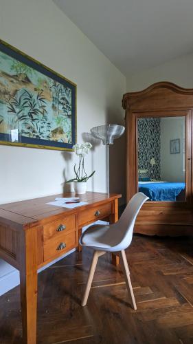 Cette chambre comprend un bureau et une chaise. dans l'établissement Le Jardin des Lys - Chambre d'hôte ou Appartement, à La Roche-Posay
