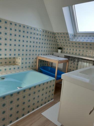 Cette chambre comprend un bureau, une table et une fenêtre. dans l'établissement Maison à Roscoff à 150 m de la thalasso et des plages, à Roscoff