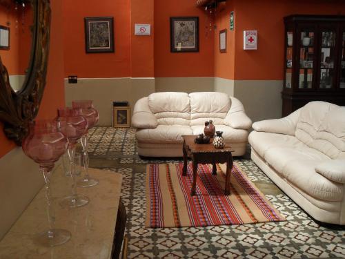 una sala de estar con 2 sofás y una mesa con copas de vino en Residencial Miraflores B&B, en Lima