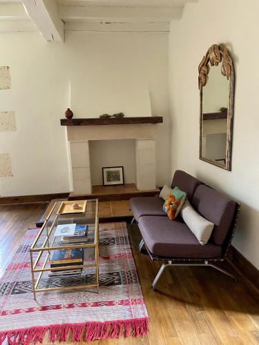 a living room with a couch and a glass table at La Colline aux Licornes in Montbron