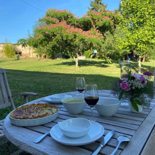 - une table de pique-nique en bois avec de la nourriture et des verres à vin dans l'établissement La Colline aux Licornes, à Montbron