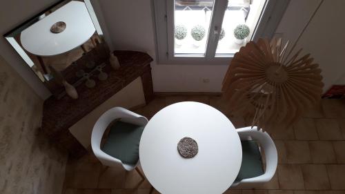 - une table et des chaises blanches dans une pièce avec un miroir dans l'établissement Appartement centre-ville avec terrasse, à Montpellier