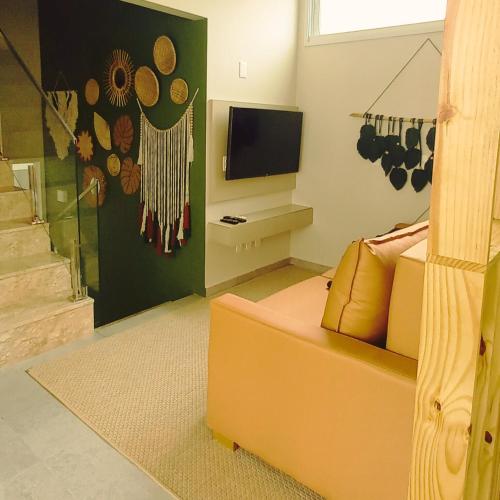 - un salon avec un canapé et une télévision dans l'établissement Casa Pipa Flamingos, à Pipa