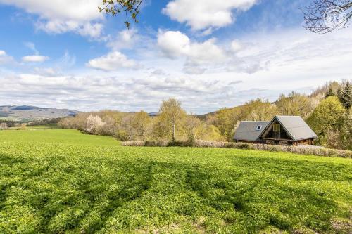 a house in the middle of a green field at Gîte de la Colombière in La Grande-Verrière