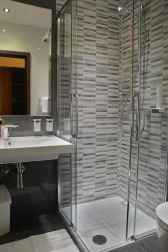 a bathroom with a glass shower and a sink at Hotel Fiesa in Piran