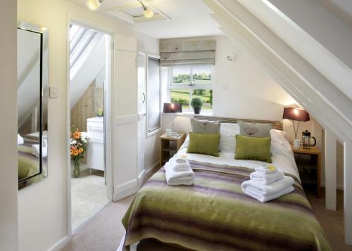 a bedroom with a bed with towels on it at Brambles in Little Dean