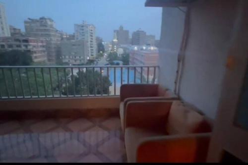 d'un balcon avec deux chaises et vue sur la ville. dans l'établissement Boho Chic Retreat in the midst of City Life, au Caire