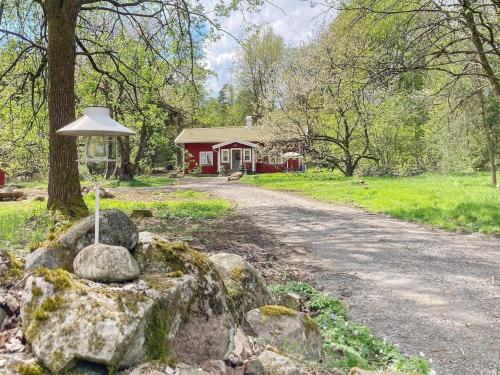 a road leading to a red house with a tree at 8 person holiday home in Hestra-By Traum in Hestra