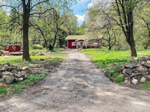 a dirt road in front of a red house at 8 person holiday home in Hestra-By Traum in Hestra
