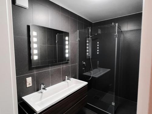 a black bathroom with a sink and a shower at Industrial Apartment in Belval the University City in Esch-sur-Alzette