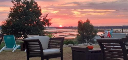 a group of chairs and a table with a sunset at ***** Quinta Do Pôr do Sol ***** in Figueira da Foz