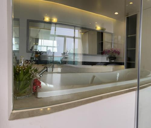 a bathroom with a large mirror and a bath tub at Hotel,Căn Hộ Mũi Né Sea link in Phan Thiet