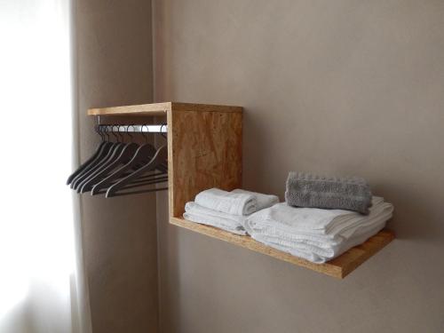 estante de madera con toallas en la pared en Affittacamere Happy, en Porto SantʼElpidio