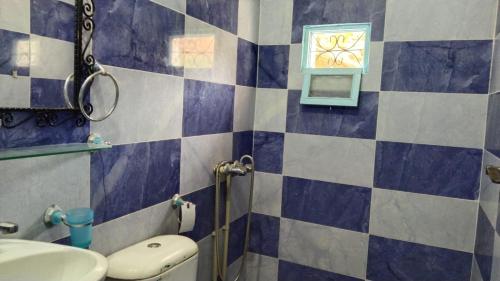 a bathroom with a blue and white tiled wall at Etoile des Gorges in Aït Baha