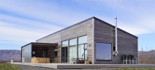 ein modernes Haus mit einem großen Glasfenster in der Unterkunft Austurey - Lakefront Villa in Laugarvatn