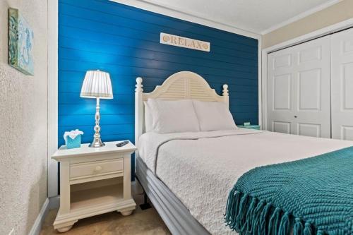 een slaapkamer met een bed en een blauwe muur bij Beachy Daze-Waterfront - WIFI - Heated Pool in Tampa