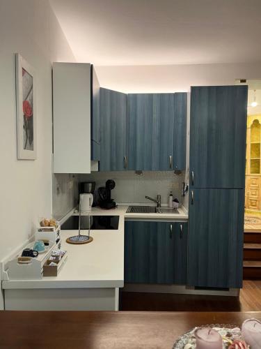 a kitchen with blue cabinets and a white counter top at Golfo Dei Poeti Apartment in Lerici