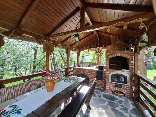 an outdoor patio with a brick fireplace and a table and chairs at Casa din livada in Borşa