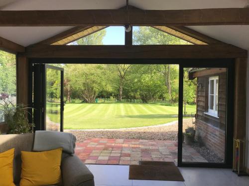 ein Wohnzimmer mit einer Glasschiebetür mit Blick auf einen Hof in der Unterkunft Garden View in Saxlingham Thorpe