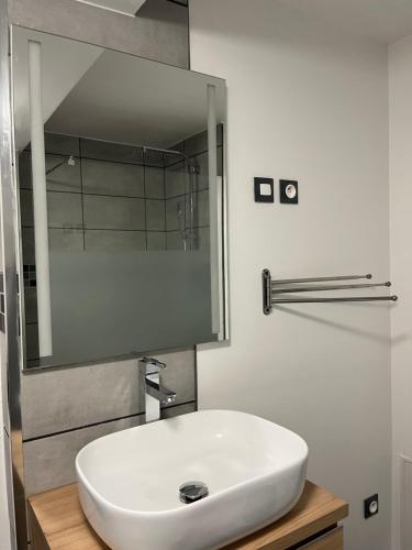 y baño con lavabo blanco y espejo. en Superbe appartement au bord du canal de St Quentin, en Saint-Quentin