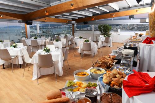 a restaurant with tables and chairs with food on them at Airotel Galaxy in Kavala