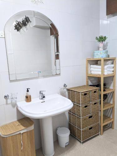 a white bathroom with a sink and a mirror at Bolboreta Nigrán in Nigrán