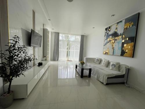 a white living room with a bed and a plant at Hotel,Căn Hộ Mũi Né Sea link in Phan Thiet