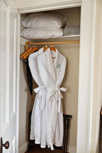 a closet filled with white towels and a bed at McCully House Inn in Jacksonville