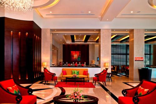 a lobby of a hotel with red chairs and a couch at Fortune Park JPS Grand Rajkot - Member ITC Hotels' Group in Rajkot
