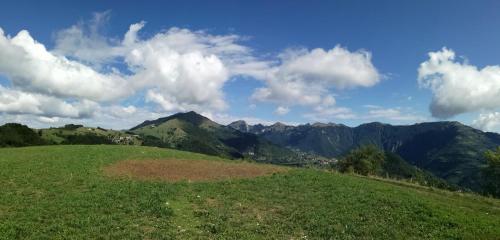 a green hill with mountains in the background at Il Sanco in Selva di Progno