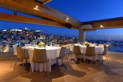 a room with tables and chairs with a view at Airotel Galaxy in Kavala