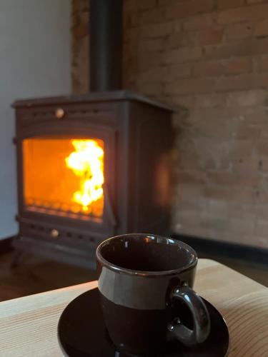a cup of coffee on a plate in front of a stove at Ublik Stacja in Ublik