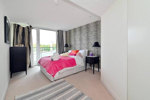 a white bedroom with a bed and a window at Queen Chelsea 77 in London