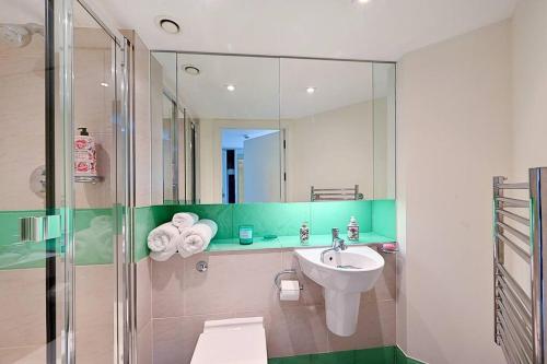 a bathroom with a sink and a shower at Queen Chelsea 77 in London